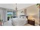 Comfortable bedroom with neutral tones, soft lighting, and sliding glass door to the backyard at 3982 Chatsworth Greene # 37, Sarasota, FL 34235