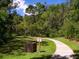 Scenic view of a nature trail surrounded by lush greenery with trash receptacle and signage at 3982 Chatsworth Greene # 37, Sarasota, FL 34235