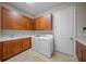 Bright laundry room with lots of cabinets, a sink and a washer and dryer set at 4109 Cascina Way, Sarasota, FL 34238