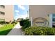 Community clubhouse with manicured landscaping and visible signage at 4133 Heron Way # E202, Bradenton, FL 34205