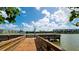 Scenic view of a wooden dock extending into a serene lake with nearby condos at 4133 Heron Way # E202, Bradenton, FL 34205