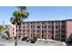 Exterior of condo building featuring multiple balconies, palm trees and parking spaces at 4133 Heron Way # E202, Bradenton, FL 34205