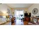 Relaxing living room features hardwood floors, TV, and sliding door to the balcony at 4133 Heron Way # E202, Bradenton, FL 34205