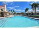 Community pool area with tables, lounge chairs and bright, refreshing water surrounded by palm trees at 4149 Salernes Ave # 3048, Sarasota, FL 34233