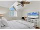 A light-filled bedroom offers a vaulted ceiling, ceiling fan, and beach scene art at 44 Tidy Island Blvd, Bradenton, FL 34210
