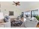 Bright living room featuring hardwood floors, ceiling fan, stylish furniture, and sliding glass doors leading to lanai at 44 Tidy Island Blvd, Bradenton, FL 34210