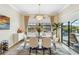 Elegant dining room featuring modern decor and large windows with view of the outdoor pool at 4856 Coastal Days Ln, Bradenton, FL 34211