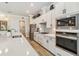 Gourmet kitchen features stainless steel appliances, white cabinets, and a tile backsplash at 4856 Coastal Days Ln, Bradenton, FL 34211