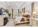 Serene main bedroom with tray ceiling, decorative fireplace and plush furnishings at 4856 Coastal Days Ln, Bradenton, FL 34211