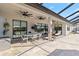 Outdoor patio with travertine tile, ceiling fans, dining table and lounge chairs perfect for entertaining at 4856 Coastal Days Ln, Bradenton, FL 34211