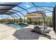 Screened-in pool area with a waterfall feature, lounge chairs, and patio at 4856 Coastal Days Ln, Bradenton, FL 34211