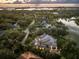 Stunning aerial view of a luxury home nestled among lush trees, overlooking bay and a serene pond at 49 Osprey Point Dr, Osprey, FL 34229