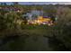 Aerial view of the home with a pond in the backyard, surrounded by trees and lush landscaping at 49 Osprey Point Dr, Osprey, FL 34229