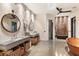 Enjoy this spa-like bathroom featuring dual sinks, a soaking tub, stone accent wall, and a glass walk-in shower at 49 Osprey Point Dr, Osprey, FL 34229