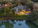 Elegant home exterior with a screened pool area, reflected beautifully in the adjacent pond at 49 Osprey Point Dr, Osprey, FL 34229