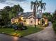 Well-lit home exterior with manicured landscaping, lush green lawn, and brick driveway at 49 Osprey Point Dr, Osprey, FL 34229