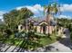 Attractive home featuring a lush front lawn, mature palm trees, and a circular driveway at 49 Osprey Point Dr, Osprey, FL 34229