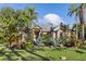 Inviting home front with mature landscaping, including palm trees and lush lawn at 49 Osprey Point Dr, Osprey, FL 34229