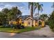 Inviting exterior showcasing manicured lawn, mature palms, and a circular paver driveway leading to the grand entrance at 49 Osprey Point Dr, Osprey, FL 34229