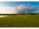 Scenic view of the green golf course, capturing the serene environment with a flag waving and lake backdrop at 49 Osprey Point Dr, Osprey, FL 34229