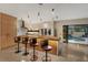 Modern kitchen with a unique island bar, contemporary stools, and a view of the private pool at 49 Osprey Point Dr, Osprey, FL 34229