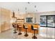 Stylish kitchen featuring a breakfast bar with modern stools and a view of the sparkling pool area at 49 Osprey Point Dr, Osprey, FL 34229