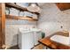 Bright laundry room with modern appliances, shelving, and counter space at 49 Osprey Point Dr, Osprey, FL 34229