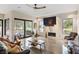 Inviting living room with modern tiled fireplace and large windows offering a serene lake view at 49 Osprey Point Dr, Osprey, FL 34229
