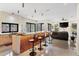 Open-concept living space featuring a modern kitchen with bar seating, a TV, and a comfortable living area at 49 Osprey Point Dr, Osprey, FL 34229