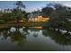 Scenic view of home and pond, with lights reflecting on the pond at dusk at 49 Osprey Point Dr, Osprey, FL 34229