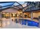 Inviting pool with a screened enclosure surrounded by ample seating areas and multiple access points into the home at 49 Osprey Point Dr, Osprey, FL 34229