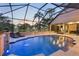 Screened-in pool area with waterfall feature and lounge chairs, complemented by views of a serene pond at 49 Osprey Point Dr, Osprey, FL 34229