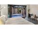 Bedroom view of the tranquil backyard pool area with a water feature through sliding glass doors at 49 Osprey Point Dr, Osprey, FL 34229