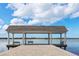 Picturesque covered pier featuring benches and an open view of the water under a bright sky at 49 Osprey Point Dr, Osprey, FL 34229