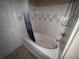Tiled bathroom featuring a shower and tub combo with blue shower curtain at 5560 Rosehill Rd # 105, Sarasota, FL 34233