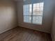 Bedroom with modern laminate floors and a large window offering natural light at 5560 Rosehill Rd # 105, Sarasota, FL 34233