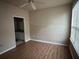 Bedroom with wood floors and a window; bathroom visible through doorway at 5560 Rosehill Rd # 105, Sarasota, FL 34233