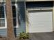 Attached one-car garage on a blue home with tan trim and a new white door at 5560 Rosehill Rd # 105, Sarasota, FL 34233