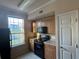 Bright kitchen featuring a black range, microwave, and view of the pond at 5560 Rosehill Rd # 105, Sarasota, FL 34233