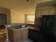 Well-lit kitchen with stainless steel sink, dark appliances, and view of the living area at 5560 Rosehill Rd # 105, Sarasota, FL 34233