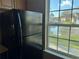 The kitchen features a black refrigerator and a window overlooking a pond at 5560 Rosehill Rd # 105, Sarasota, FL 34233