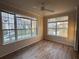 Sunlit living room features hardwood-style flooring, large windows with pleasant neighborhood views at 5560 Rosehill Rd # 105, Sarasota, FL 34233
