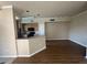 Open-concept living area with wood-look floors flowing into kitchen with breakfast bar and black appliances at 5560 Rosehill Rd # 105, Sarasota, FL 34233
