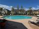 Inviting community pool with lounge chairs and surrounding residential buildings under a clear blue sky at 5560 Rosehill Rd # 105, Sarasota, FL 34233