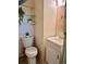 Small bathroom featuring a toilet, sink, and shelves with lush greenery at 5791 Holiday Park Blvd, North Port, FL 34287