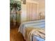 Bright bedroom showcasing a tropical theme, complemented by light-colored closets and laminate wood floors at 5791 Holiday Park Blvd, North Port, FL 34287