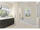 Bright bathroom with double vanity, soaking tub under a shuttered window, and tile flooring at 581 Mast Dr, Bradenton, FL 34208
