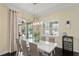 Dining room with a bright modern chandelier and sliding glass doors that lead to an outdoor living area at 581 Mast Dr, Bradenton, FL 34208