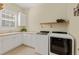 Bright laundry room with front loading washer and dryer and window over utility sink at 581 Mast Dr, Bradenton, FL 34208