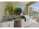 Outdoor kitchen with stainless steel grill, granite countertops, and a sink, perfect for outdoor cooking and entertaining at 581 Mast Dr, Bradenton, FL 34208